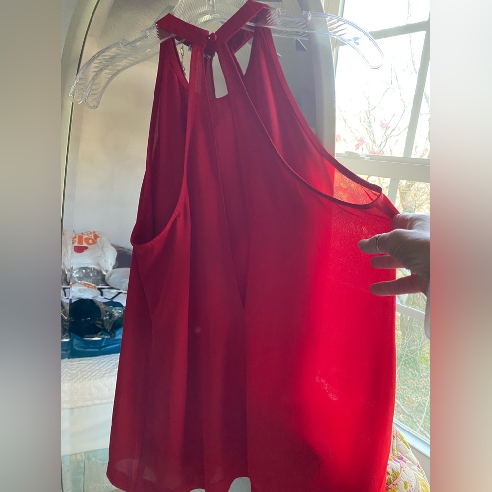 Sleeveless red dressy alter top with back slit .